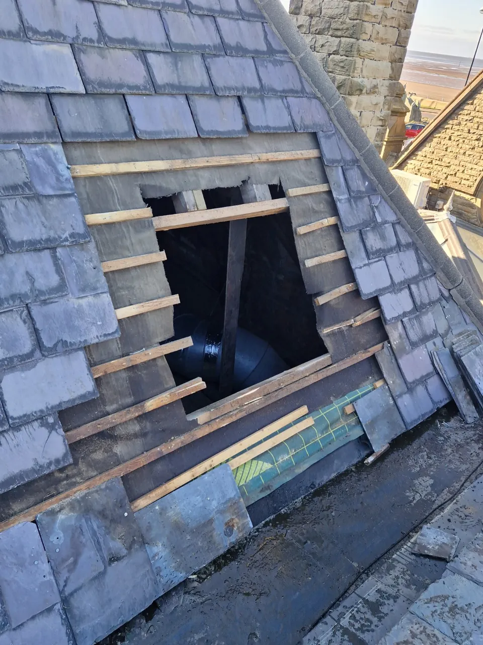 Roof opening after removal of the external extractor assembly, with battens and underlay exposed.