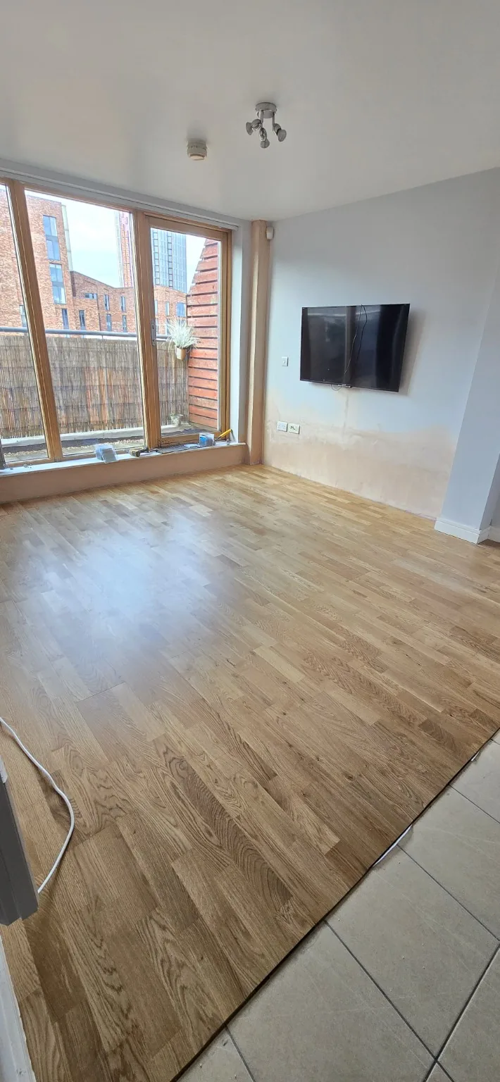 Replacement floor finish laid in the living room while lower wall surfaces await final decoration.