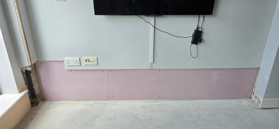 Replacement plasterboard fitted to the lower section of the television wall.