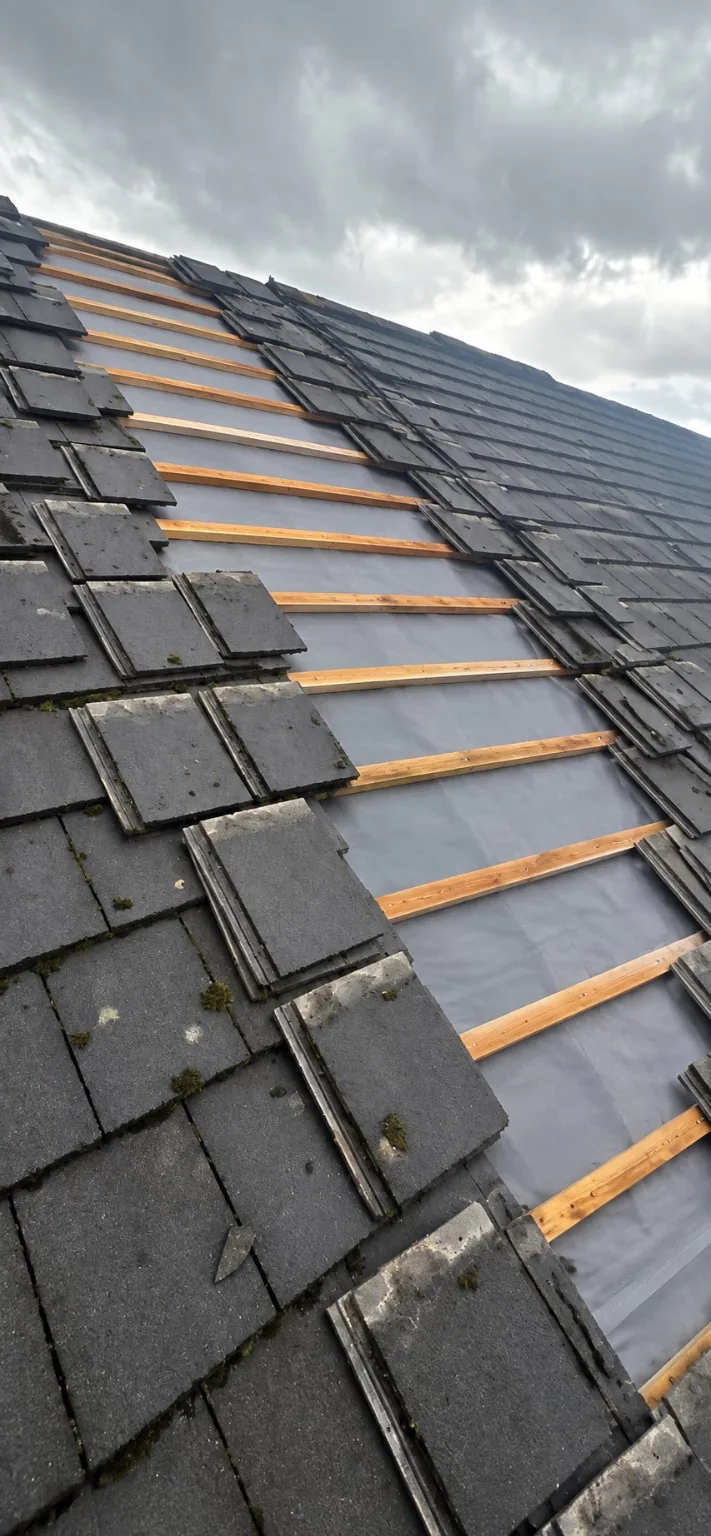 Roof tiles lifted to expose the membrane and timber battens during the Newton-le-Willows repair.