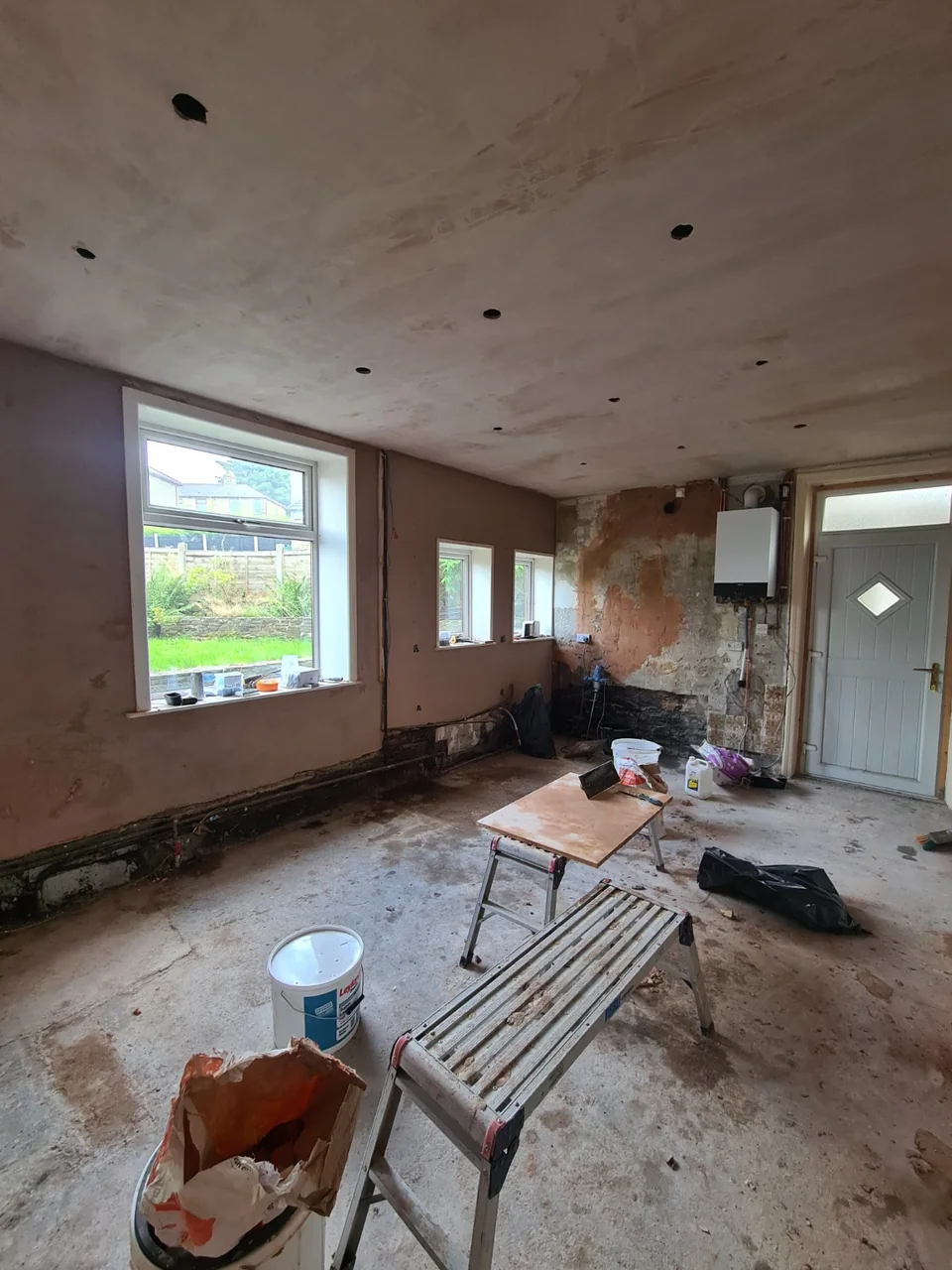 The opened-up Rawtenstall kitchen during preparation, with plastered surfaces and the old kitchen removed.