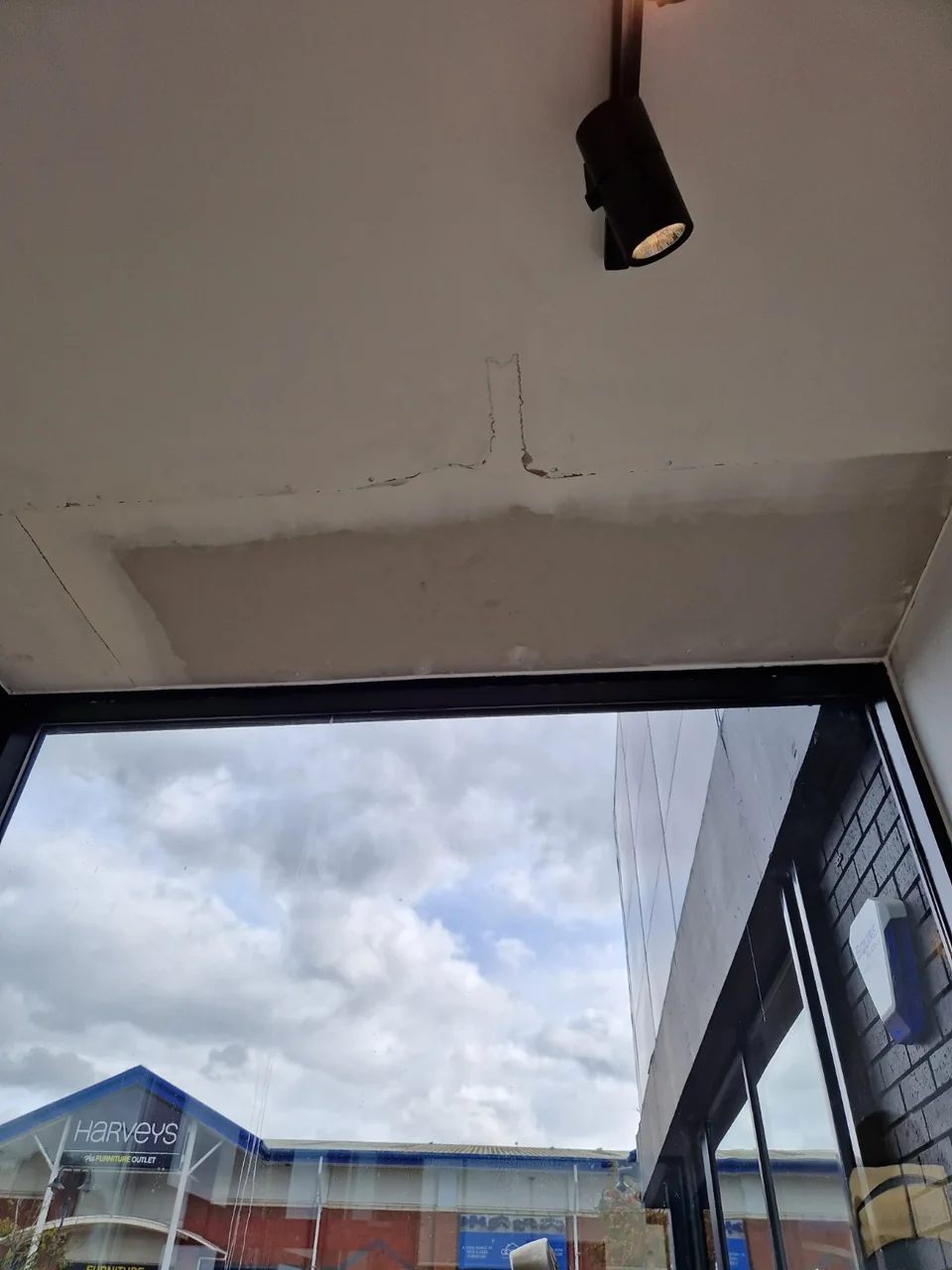 Ceiling patch above the glazing with joints and unfinished edges visible before final preparation and decoration.