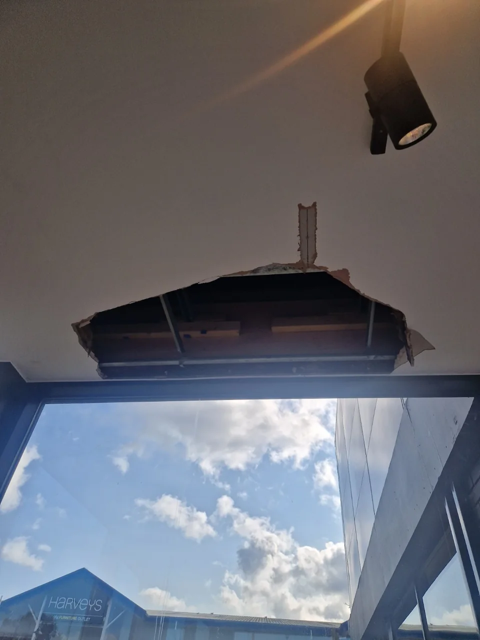 Open section of ceiling above the glazed frontage, exposing the structure behind the ceiling lining.