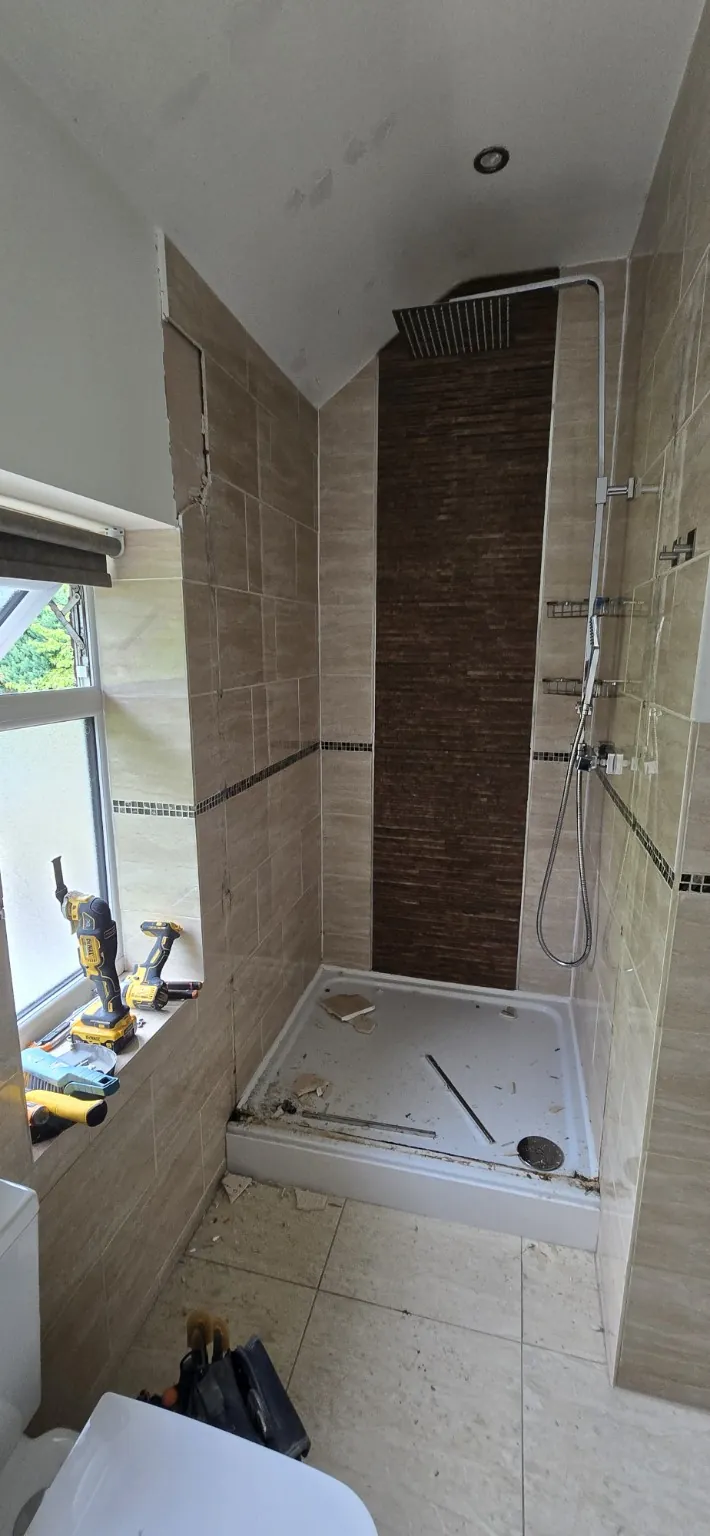 Original shower tray and tiled enclosure during initial strip-out of the Worsley bathroom.